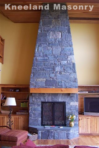 Stone fire place in a room with high celings